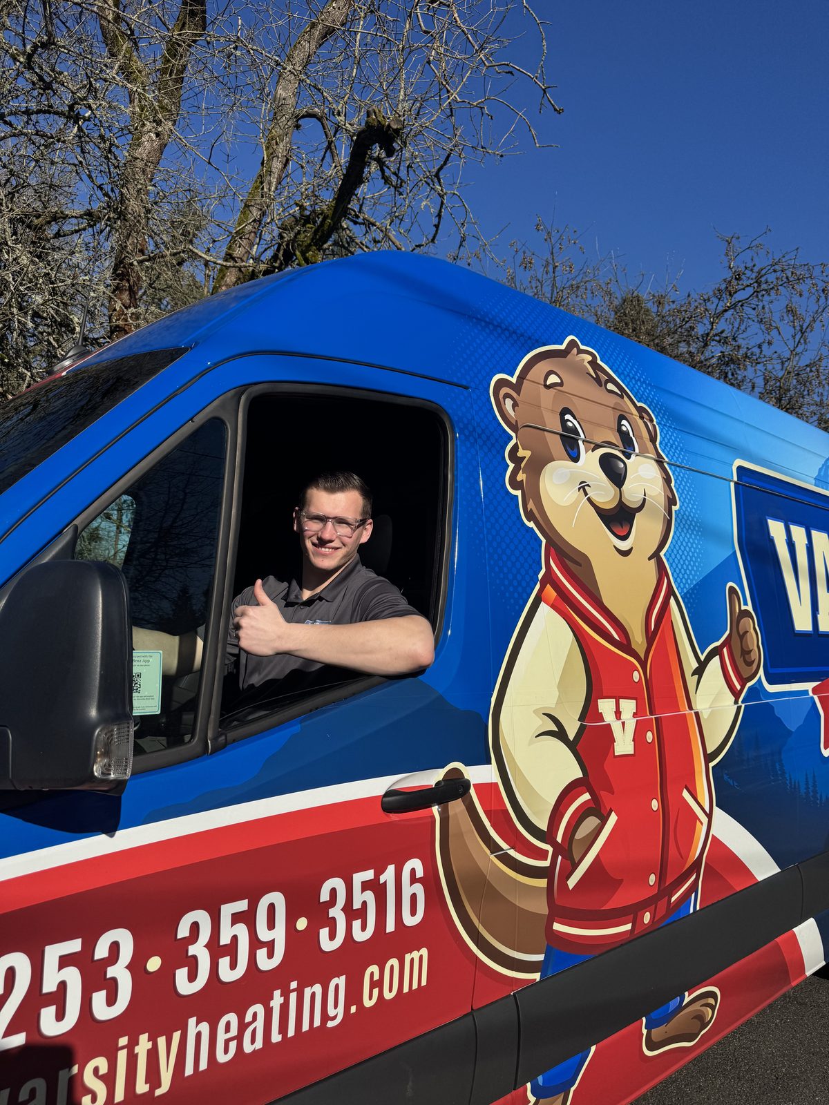 Vlad, co-owner of Varsity, giving a thumbs up from the driver's seat of a Varsity van